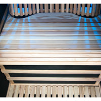 Wooden slatted seat frame with a black mattress on a dark background
