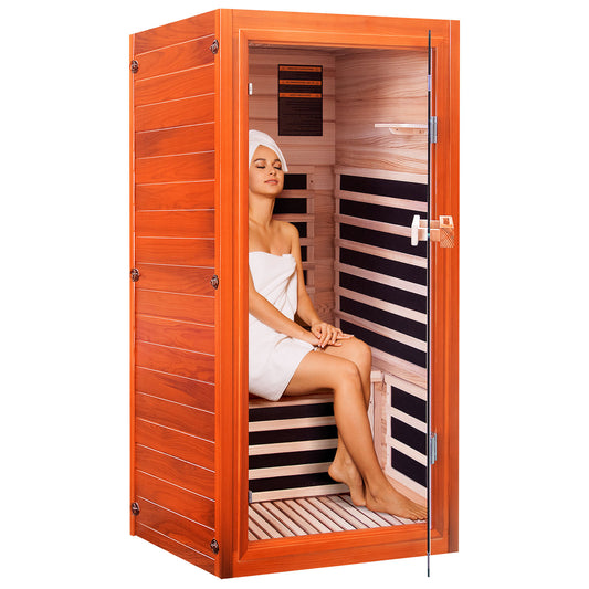 Woman sitting inside a wooden infrared sauna with striped interior.