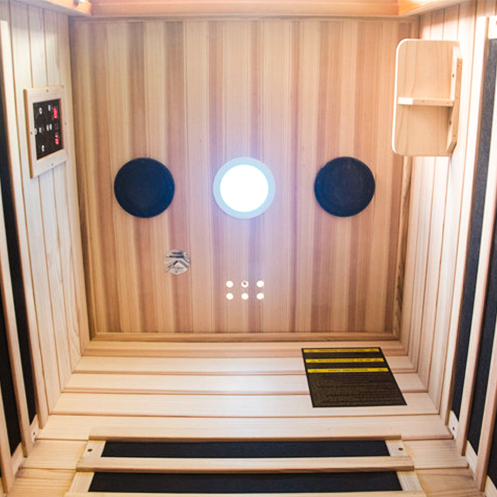 Infrared sauna with wooden walls and a control panel.