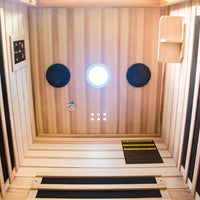 Infrared sauna with wooden walls and a control panel.