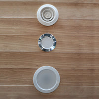 Three circular metallic objects on a wooden