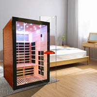 Outexer Infrared sauna in a bedroom setting with wooden floor and bed.