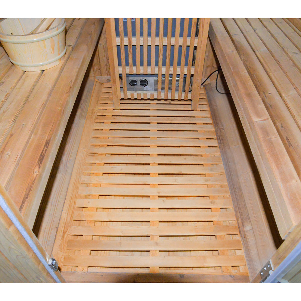 Wooden barrel sauna interior with a bench and heater.